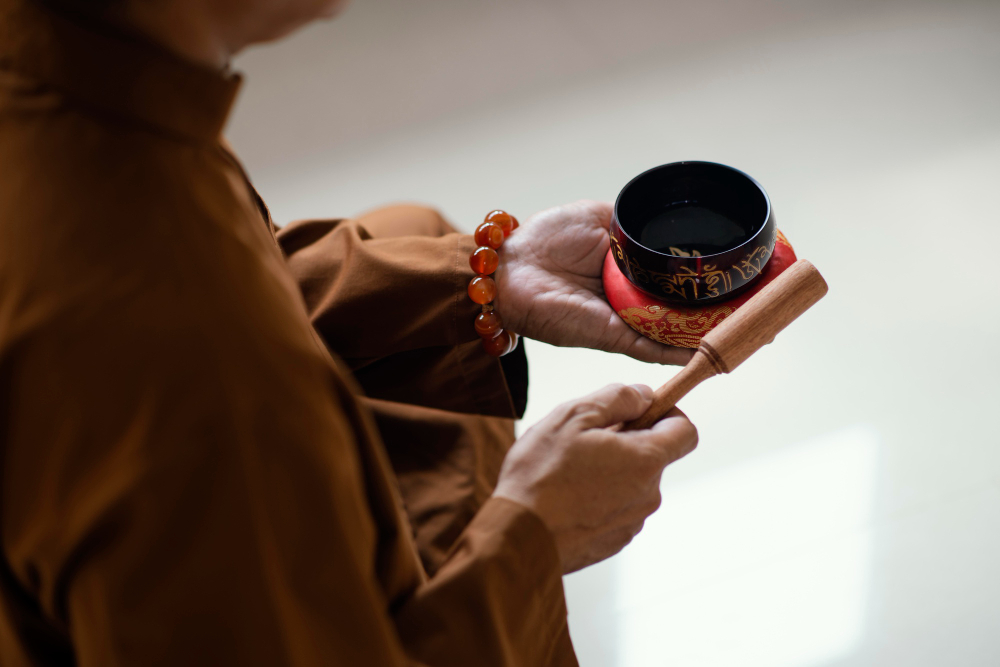 Hands holding a singing bowl and striker