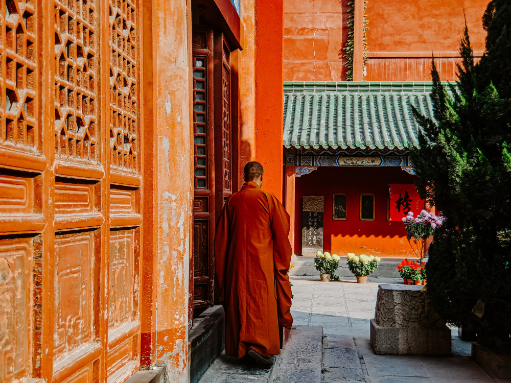 Monk walking through a traditional temple courtyard
